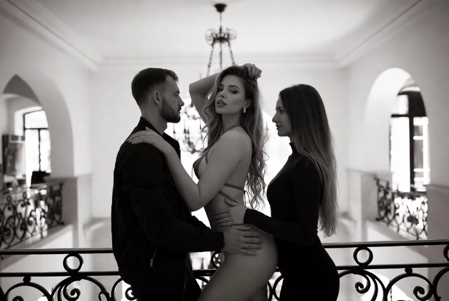 Open minded couple with a beautiful escort model companion between them